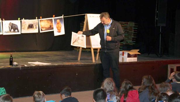 Ein Mann hält einen Vortrag vor Kindern über prähistorische Kunst.