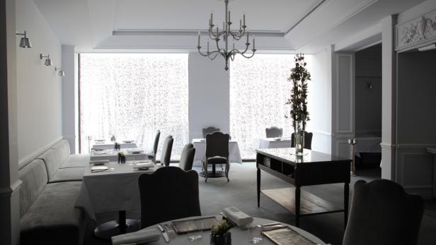 Ein elegant eingerichtetes Restaurant mit Tischen und Stühlen für Gäste.