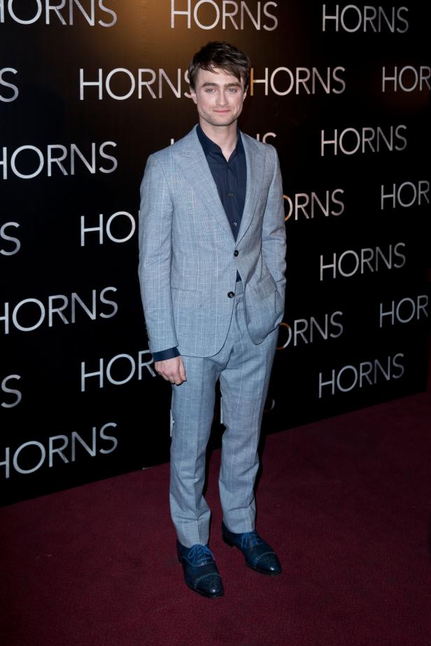 Daniel Radcliffe posiert vor einer Wand mit dem Titel „Horns“.