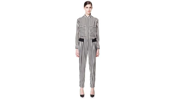 Eine Frau trägt einen gestreiften Hosenanzug und schwarze Schuhe.