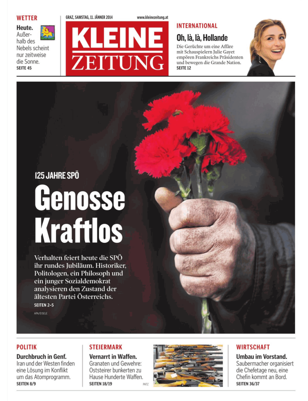 Eine Hand hält einen Strauß roter Nelken vor dem Hintergrund der Titelseite der Kleinen Zeitung.