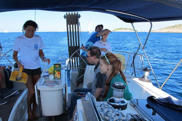 Eine Gruppe von Menschen segelt auf einer Yacht auf dem Meer.