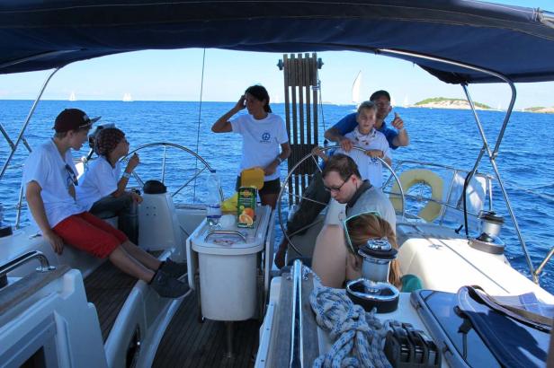 Eine Gruppe von Menschen segelt auf einer Yacht auf dem Meer.