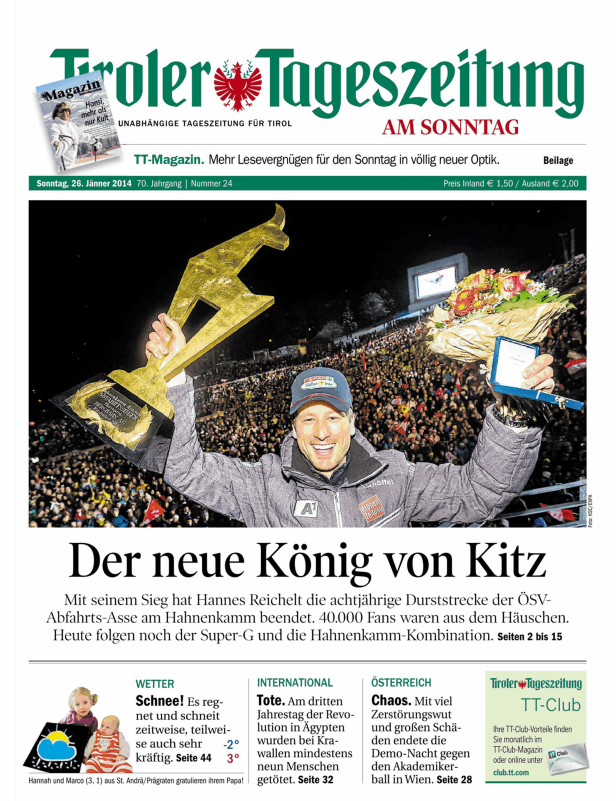 Hannes Reichelt feiert seinen Sieg beim Hahnenkammrennen in Kitzbühel mit Pokal und Blumenstrauß.