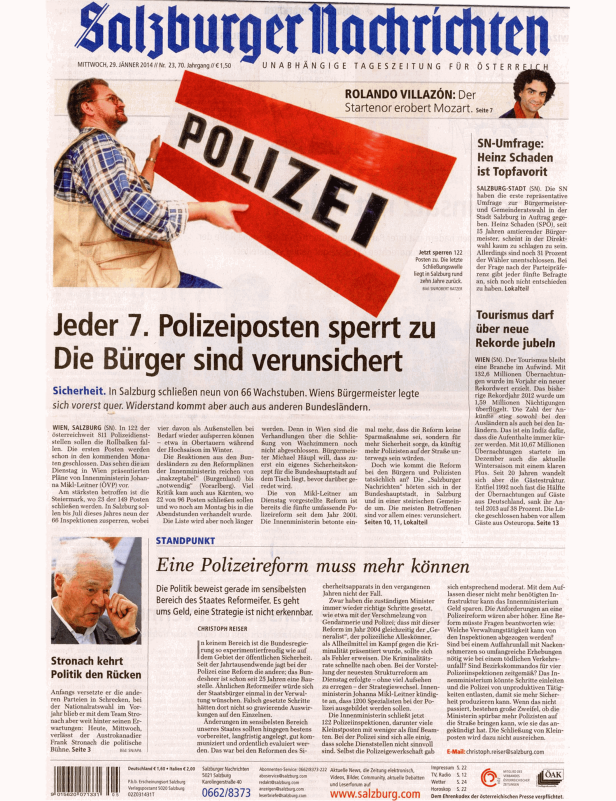 Ein Mann hält ein rot-weißes Absperrband mit der Aufschrift „Polizei“ vor eine Zeitung.