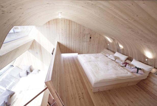 Ein Schlafzimmer mit Holzwänden und einem Bett mit Geschenken darauf.