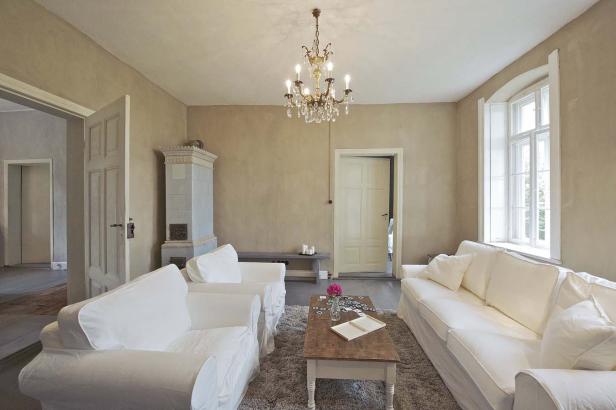 Ein Wohnzimmer mit weißen Möbeln, einem Kamin und einem Kristalllüster.