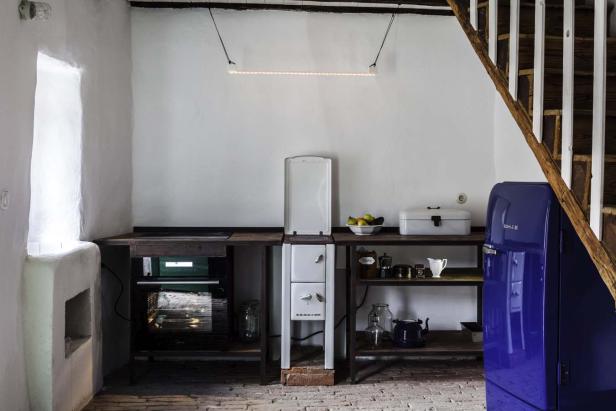 Eine Küche im Landhausstil mit blauem Kühlschrank und Holztreppe.