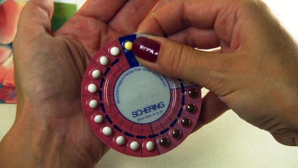 Eine Frau hält eine Schering-Antibabypille in der Hand.
