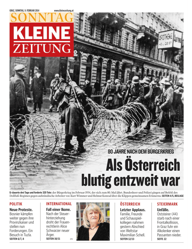 Eine Schwarzweißaufnahme von Soldaten hinter Stacheldraht während des österreichischen Bürgerkriegs 1934.