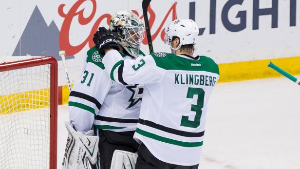 Ein Eishockeytorwart und ein Spieler der Dallas Stars umarmen sich auf dem Eis.