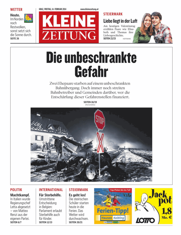 Ein zerstörtes Auto an einem Bahnübergang mit einem Stoppschild im Vordergrund.