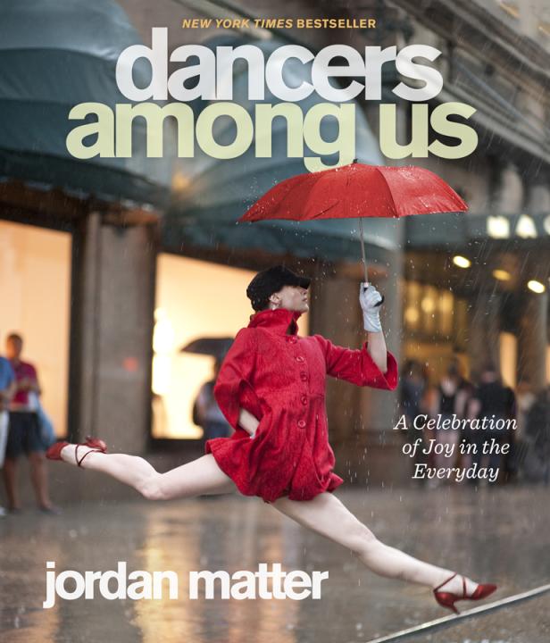 Das Cover des Buches „Dancers Among Us“ von Jordan Matter zeigt eine Tänzerin im Spagat unter einem roten Regenschirm.