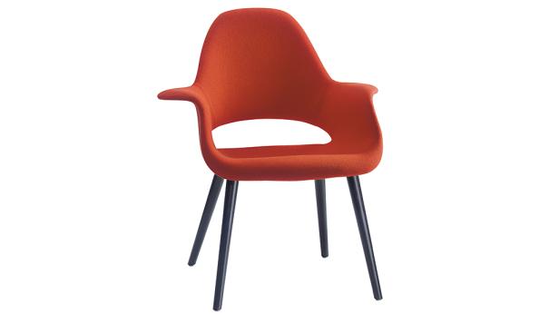 Ein orangefarbener Sessel mit schwarzen Beinen vor einem weißen Hintergrund.
