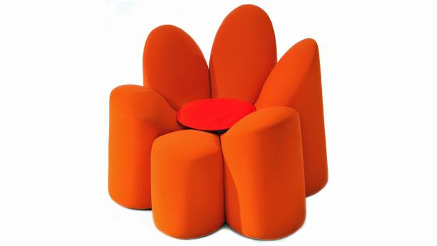 Ein orangefarbener Sessel in Form einer Blume mit einem roten Kissen in der Mitte.