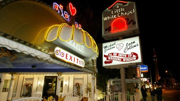 Die „Little White Chapel“ in Las Vegas mit Leuchtreklamen und Hinweisschildern, darunter eines mit Michael Jordan und Joan Collins.