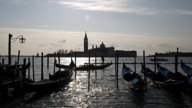 Venezianische Gondeln schaukeln im Wasser, im Hintergrund die Silhouette von San Giorgio Maggiore.