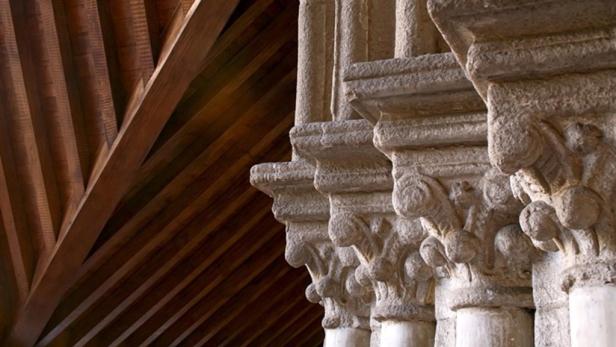 Detailaufnahme von verzierten Steinsäulen und einer hölzernen Deckenkonstruktion.