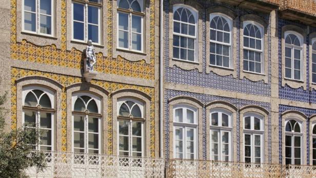 Die Fassade eines Gebäudes ist mit gelben und blauen Mustern und Fenstern verziert.