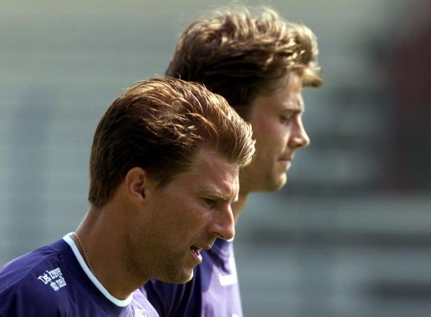 Zwei Männer in Sportkleidung stehen nebeneinander.