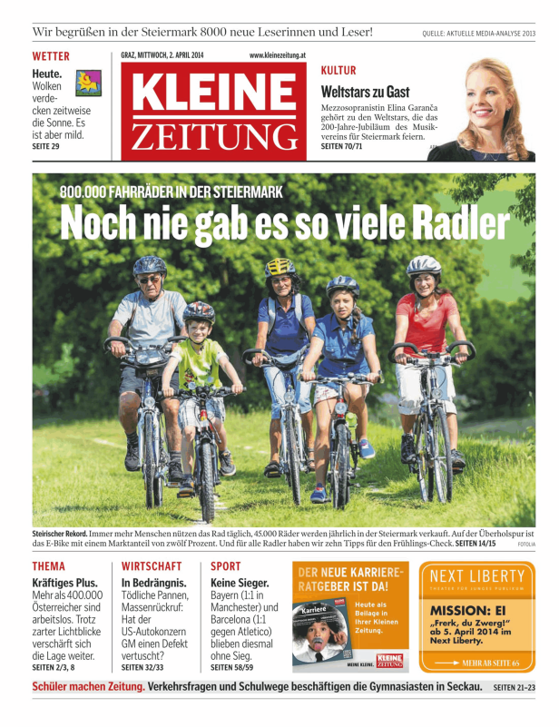 Eine Gruppe von Radfahrern, darunter Kinder und Erwachsene, fährt auf einem grünen Weg.