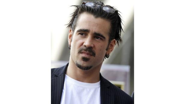 Porträt von Colin Farrell mit Brille auf dem Kopf und Ohrringen.