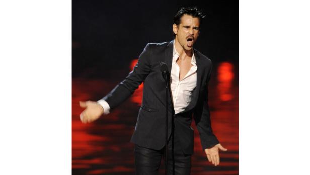 Colin Farrell gestikuliert bei einer Rede auf einer Bühne.