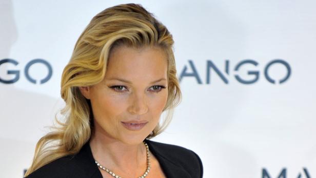 Kate Moss posiert vor einem Mango-Logo.
