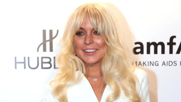 Lindsay Lohan posiert auf einer Veranstaltung vor den Logos von Hublot und amfAR.