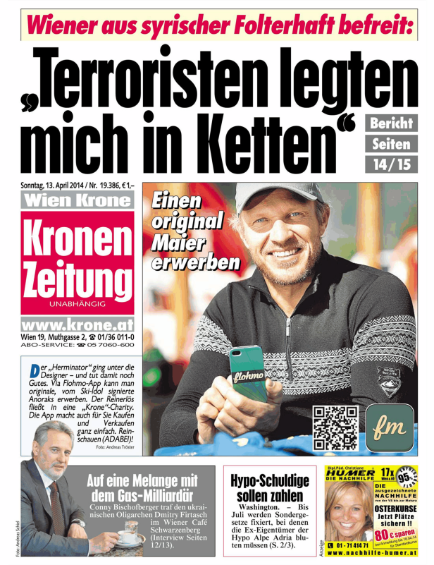 Ein Mann lächelt und hält ein Smartphone mit der Aufschrift „flohmo“ in der Hand.