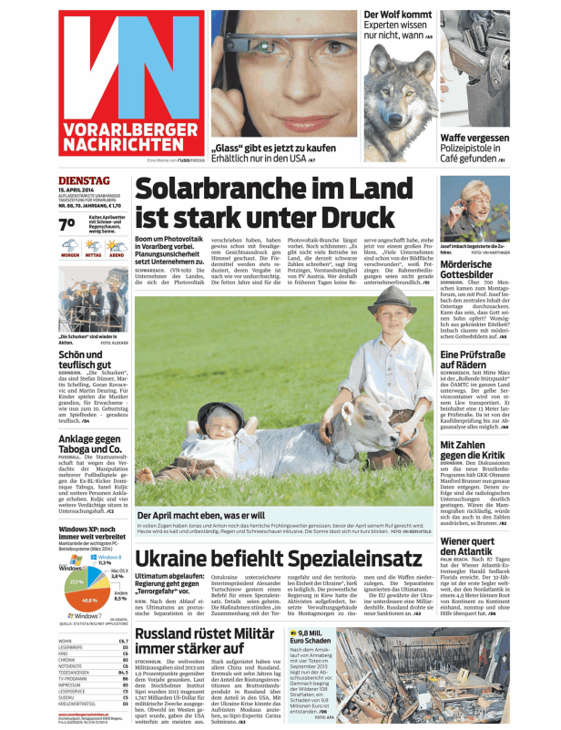 Ein Junge liegt mit einem Kalb auf einer Wiese.