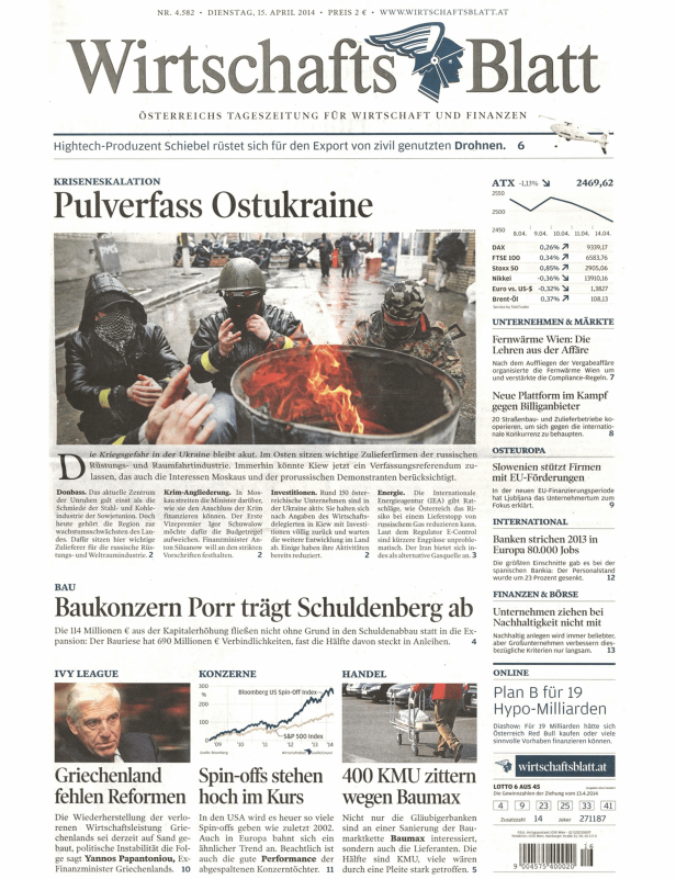 Männer wärmen sich an einem Feuer in der Ostukraine, während im Hintergrund Barrikaden zu sehen sind.