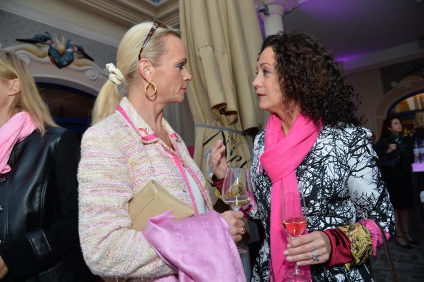 Zwei Frauen unterhalten sich bei einem Glas Sekt.