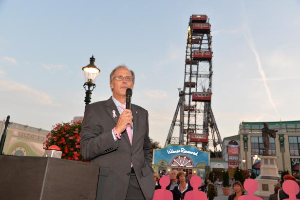 Ein Mann spricht vor dem Wiener Riesenrad in Wien.
