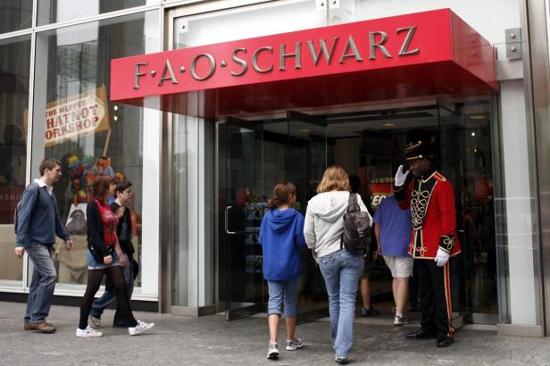 Menschen betreten das Spielwarengeschäft F.A.O. Schwarz, bewacht von einem uniformierten Mitarbeiter.