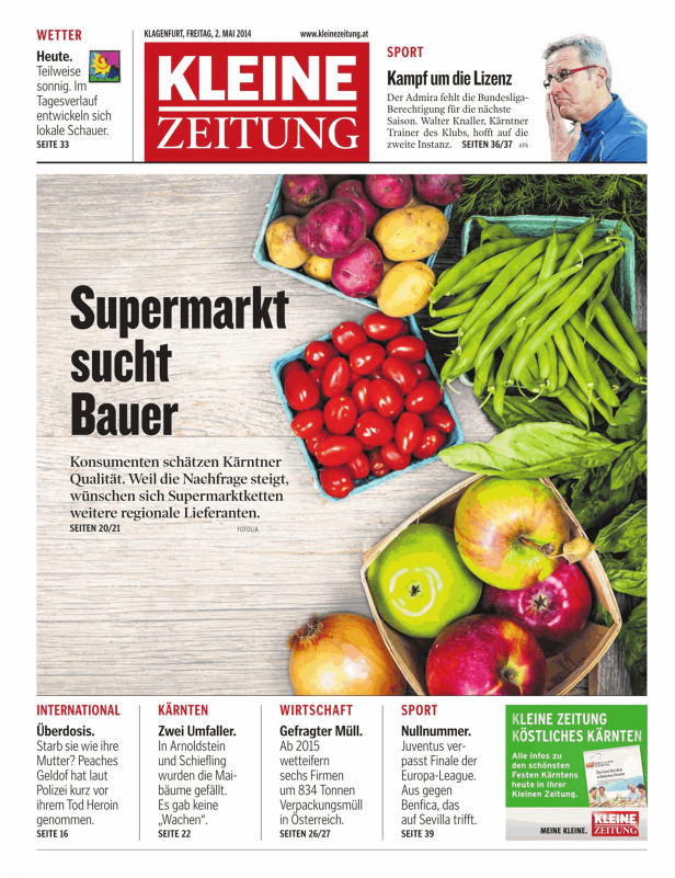 Verschiedene Gemüsesorten und Äpfel in kleinen Körben auf einem Holztisch.