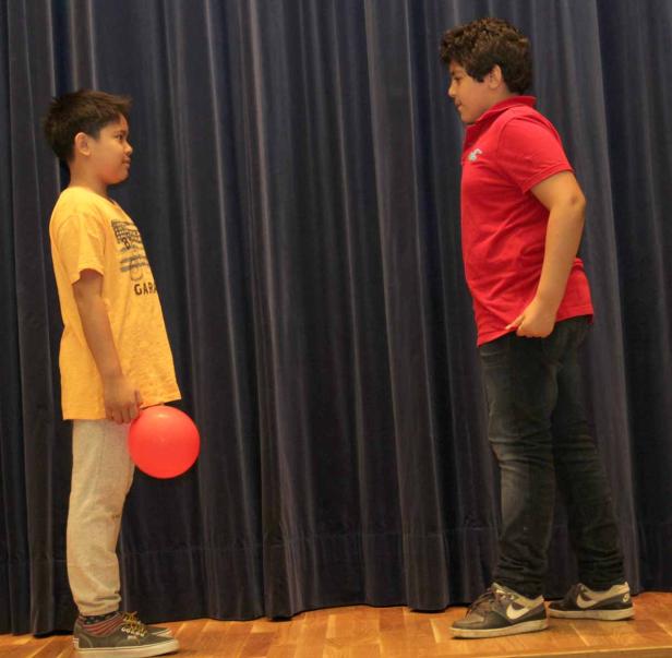 Zwei Jungen stehen sich auf einer Bühne gegenüber.