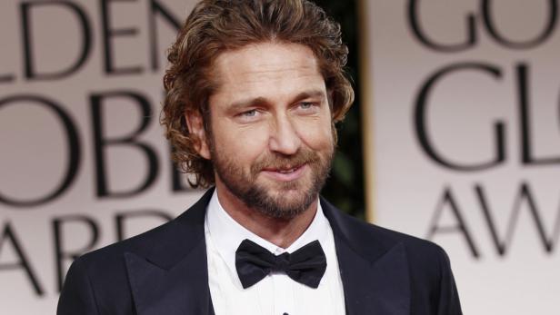 Porträt von Gerard Butler mit Fliege vor dem Hintergrund der Golden Globe Awards.