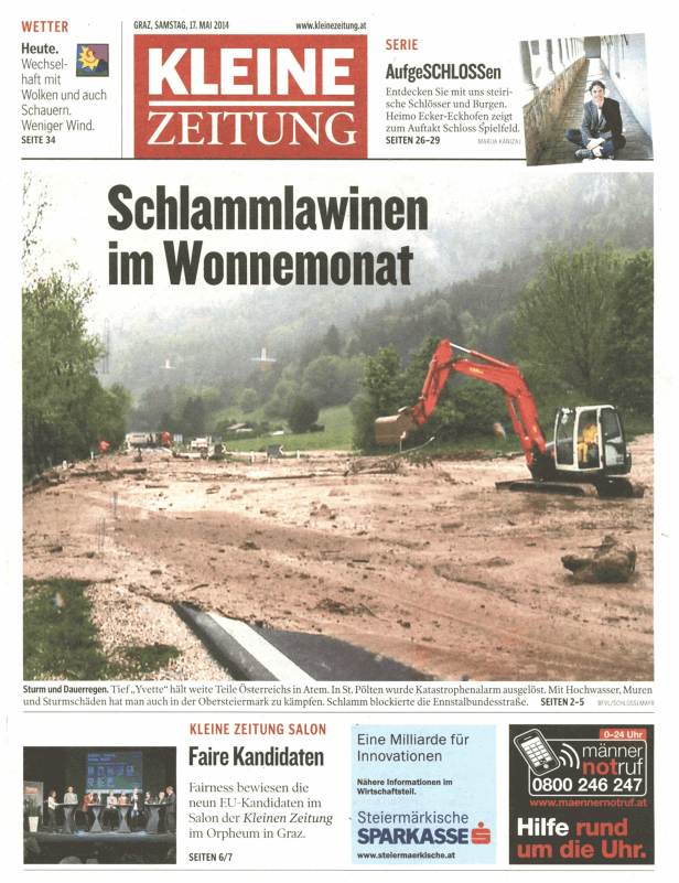 Ein Bagger räumt Schlamm nach Überschwemmungen in einer ländlichen Gegend.