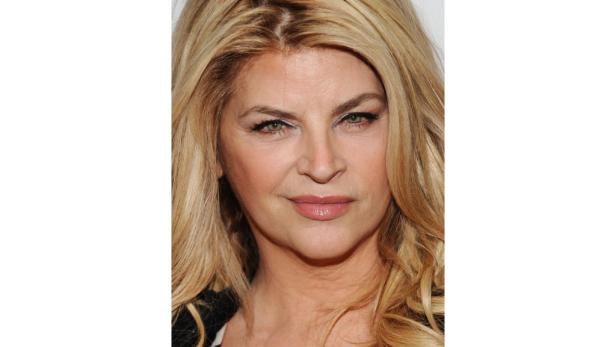 Ein Porträt von Kirstie Alley mit blonden, gewellten Haaren.