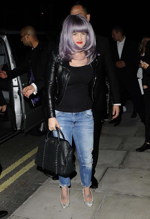 Kelly Osbourne verlässt ein Gebäude mit Bodyguards.