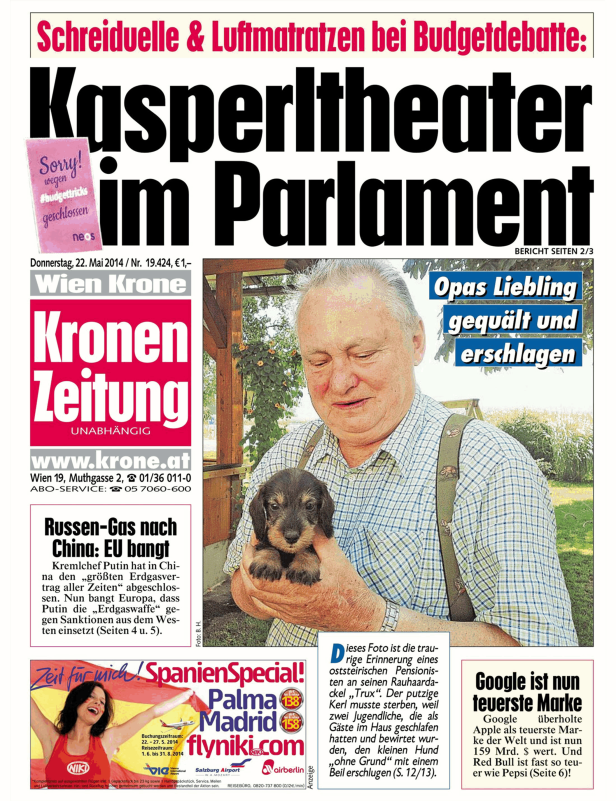 Ein Mann hält einen kleinen Dackelwelpen in den Händen.