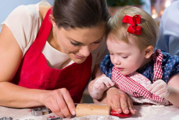 Eine Mutter backt mit ihrer kleinen Tochter Weihnachtsplätzchen.