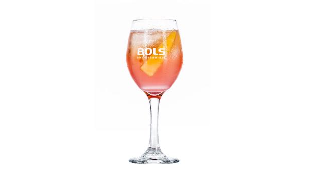 Ein Glas mit einem rosa Cocktail und einer Orangenscheibe, dekoriert mit dem Bols-Logo.