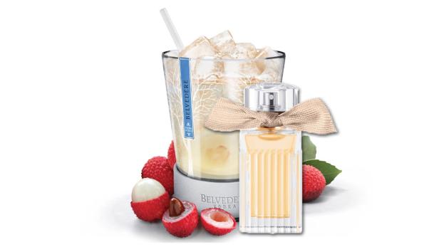 Ein Glas Belvedere-Wodka-Cocktail mit Litschis und einer Flasche Parfüm.