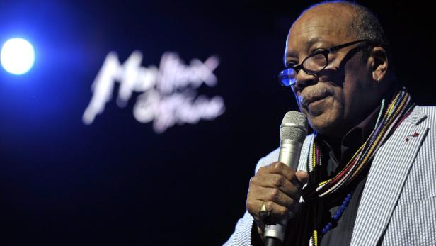Quincy Jones spricht bei einer Veranstaltung in ein Mikrofon.