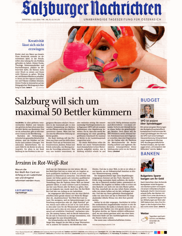 Ein Kind mit bunten Farben im Gesicht und an den Händen blickt in die Kamera.