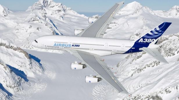 Ein Airbus A380 überfliegt eine schneebedeckte Berglandschaft.