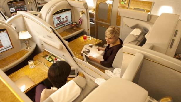 Zwei Frauen sitzen in luxuriösen Flugzeugsitzen und entspannen sich.