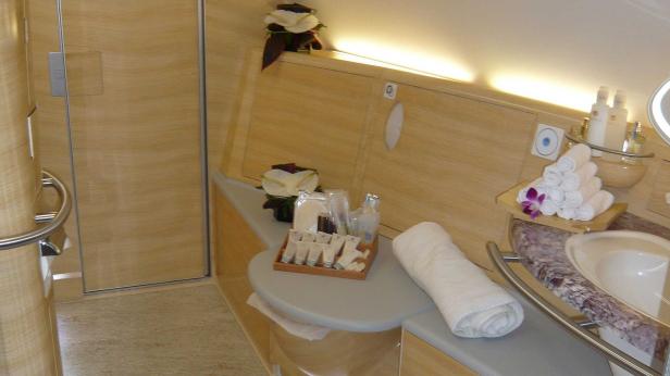 Ein Badezimmer mit Holztäfelung, Handtüchern und Pflegeprodukten.